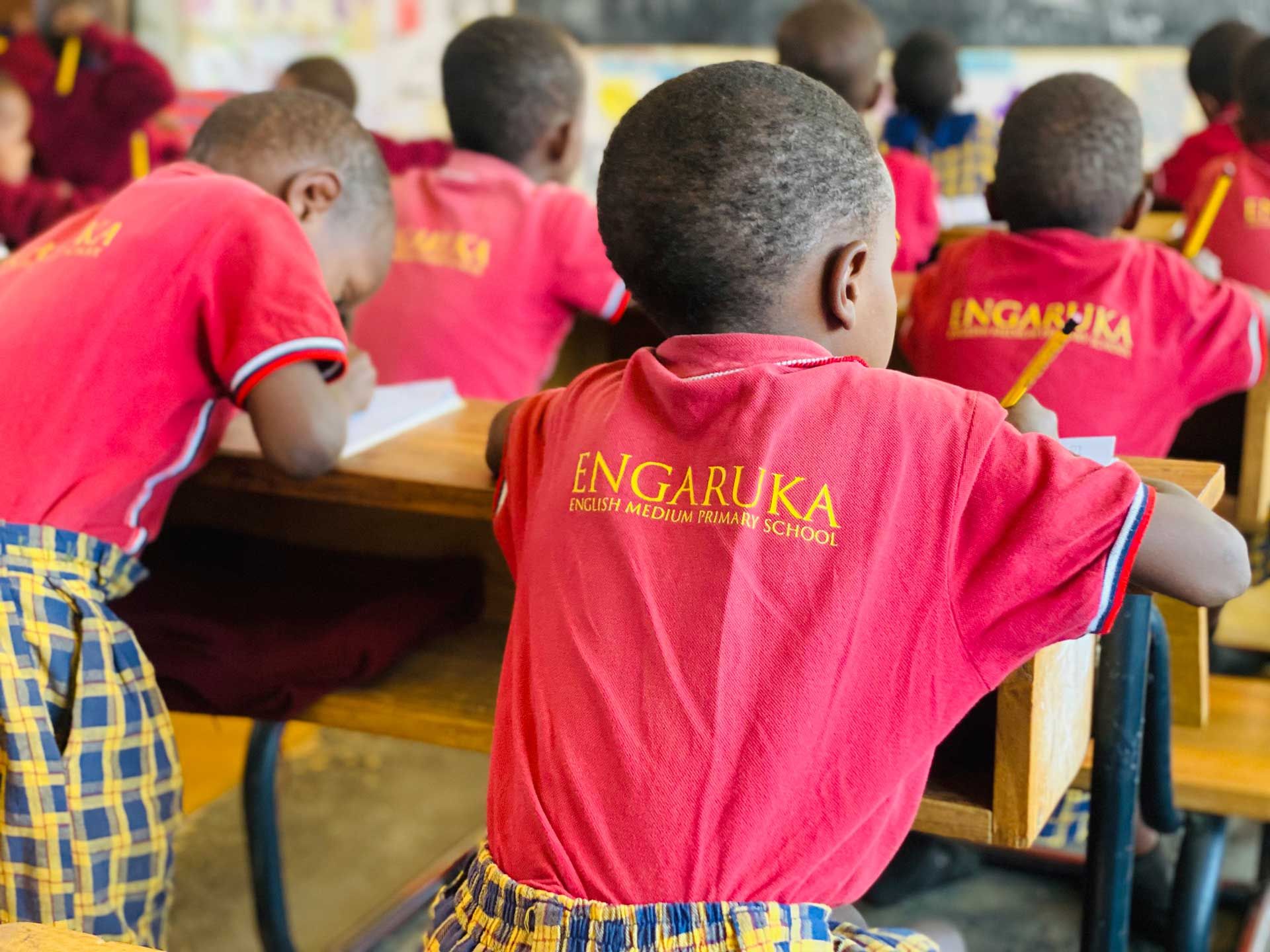 African school children at desks taking notes.